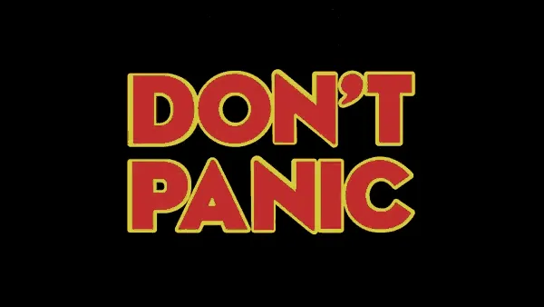 “DON'T PANIC” em letras vermelhas com contorno amarelo sobre preto, com o polegar do carona atravessando entre as duas palavras.