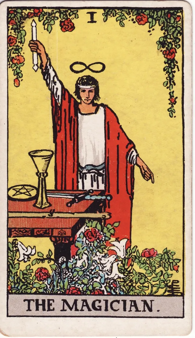 A carta O Mago, do tarô Rider-Waite-Smith: uma figura de manto vermelho com o bastão erguido e, na mesa, a taça, a espada, o pentáculo e o bastão.