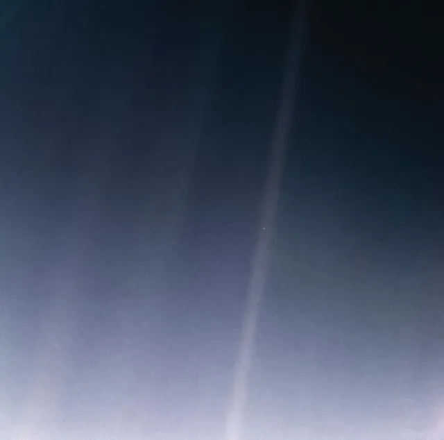 A foto do pálido ponto azul, da Voyager 1: faixas de luz solar espalhada no escuro, e a Terra como um ponto claro minúsculo numa delas.