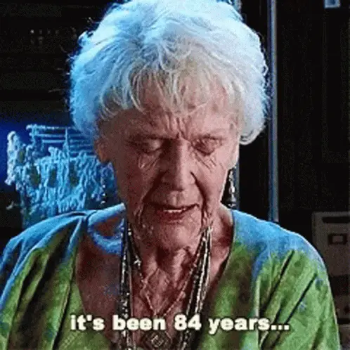 A Rose idosa, de Titanic, de olhos baixos, fala devagar; a legenda diz: it's been 84 years...